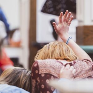 woman holding her hand up in prayer